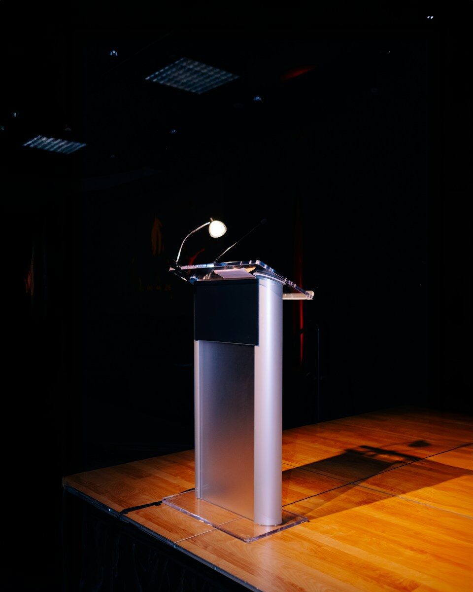 A modern podium with a microphone on a stage